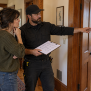 An electrician reviews a floor plan with a homeowner in an older home